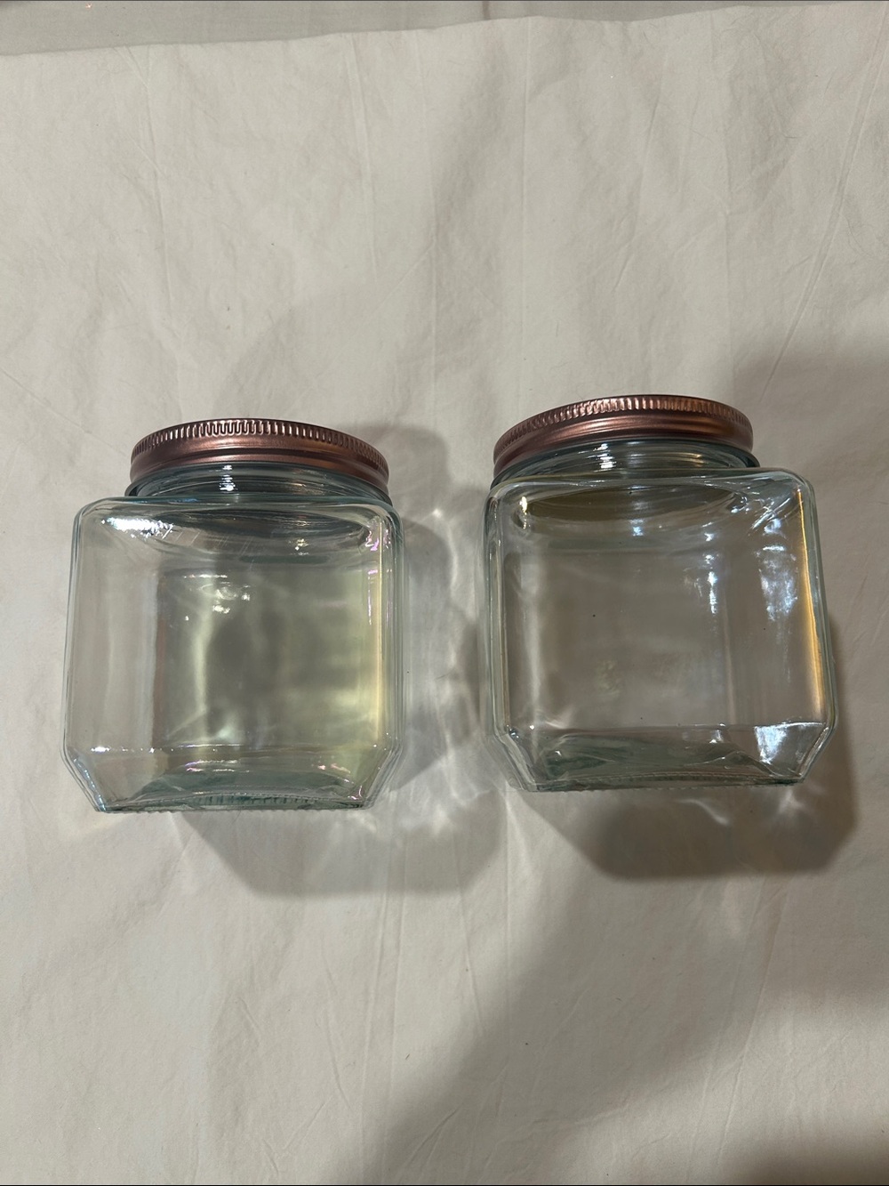 Two square jars with rose gold lids.